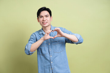 Photo of young Asian man on green background