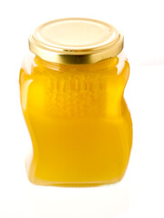 Glass bottle of fine honey with golden lid on white background. Agriculture organic product famous for its sweet taste and health benefits and value.
