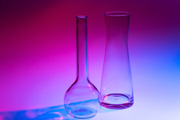 Close-up of two decorative glass vases on a red, blue and violet colored background