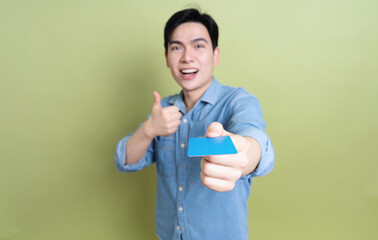 Photo of young Asian man on green background