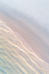 shore of a beach at sunrise, aerial above view with drone