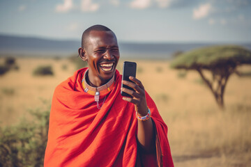Masai man using mobile phone in traditional attire on savanna