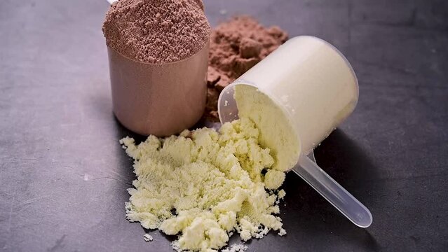 Whey white vanilla protein powder in scoops. Food supplement, nutrition, healthy lifestyle. 