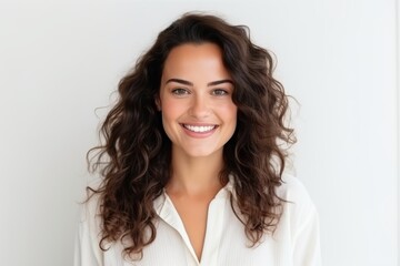 Portrait of a beautiful young woman with curly hair smiling at the camera