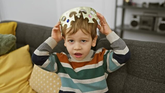 Toddler boy playing with a crown in a cozy living room setting, showcasing childhood innocence and imagination.