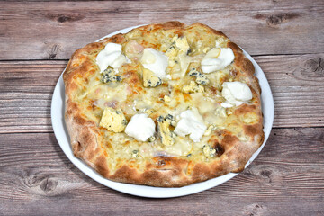 Italian Pizza whit four cheeses called quattro formaggi in a plate isolated on wooden background