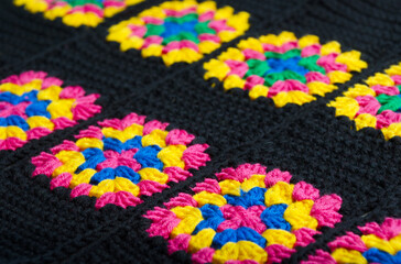 Colorful cotton granny square. Crochet texture close up photo.