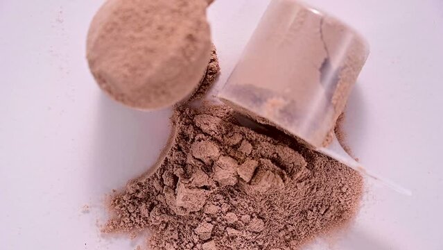 Chocolate whey protein powder in scoops, cocoa whey powder. food supplement, nutrition 