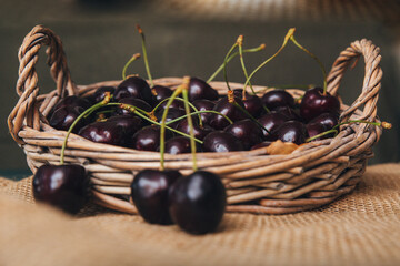 summer black cherry berries in a wicker bag close-up side view