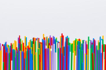 Heap of colorful plastic drinking straws on Colored background, flat lay. Copy Space for text