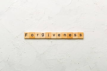 forgiveness word written on wood block. forgiveness text on table, concept