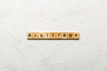 Arbitrage word written on wood block. Arbitrage text on cement table for your desing, concept