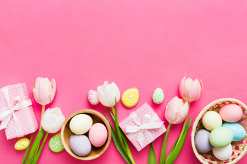 Easter frame with eggs, gift box and tulip on a colored background. The minimal concept. Top view...