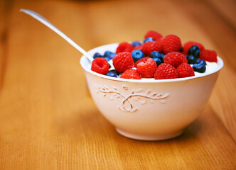 Wood, berries and bowl with yogurt, raspberry and blueberry for organic snack. Food, cuisine and breakfast for health, wellness and diet for morning nutrition and antioxidant wellbeing in studio