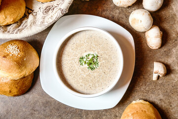 Bowl of Soup With Rolls and Mushrooms