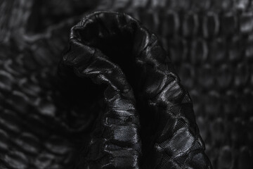 Close-up of texture of black Gagliano fabric with oval pattern. Background, texture of draped suit...