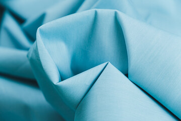 Close-up of texture of cotton fabric in light cyan blue color. Background, texture of draped fabric...