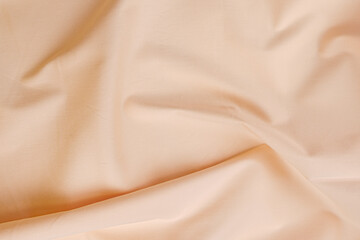 Texture of cotton fabric in peach sorbet orange color, top view. Background, texture of draped...
