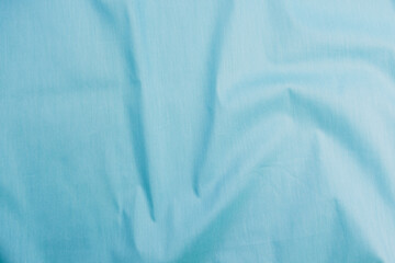 Texture of cotton fabric in light cyan blue color, top view. Background, texture of draped fabric...