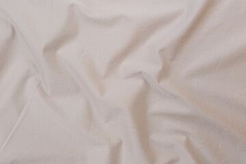 Texture of cotton fabric in silver-beige color, top view. Background, texture of draped fabric...