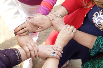 Close up shot of hands. Ladies showing unity. holding each other's hand. diversity, equality....