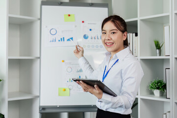 woman standing in front of whiteboard with tablet for present Profit analysis of company while...