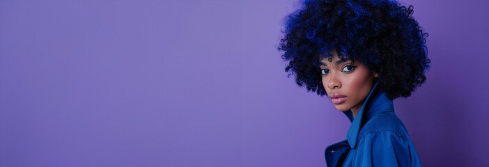 A woman with blue hair and a blue shirt is standing in a field of purple flowers. model with blue afro hair wearing a blue trench in a full body photoshoot like wild flower composition blue and purple - Powered by Adobe