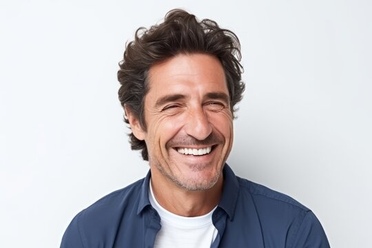 Portrait of happy mature man laughing and looking at camera against white background