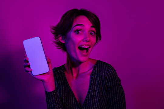 Photo portrait of lovely young lady hold excited white screen dressed stylish overall garment isolated on neon light pink color background