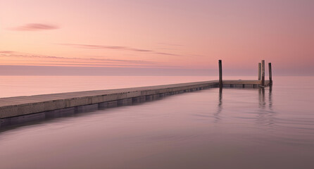 Obraz premium A lengthy wooden dock stretching out across a body of water, creating a pathway over the tranquil surface