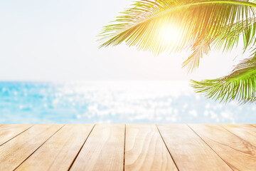 Old wooden table with turquoise water, coconut palm leaves and blue sky background. - 758783038