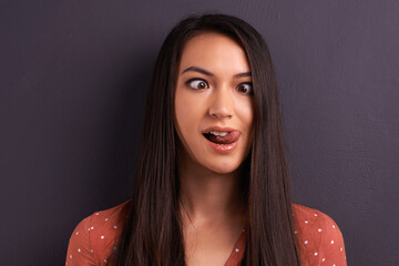 Woman, funny face and studio for comedy tongue out or mockup space, grey background or humor....
