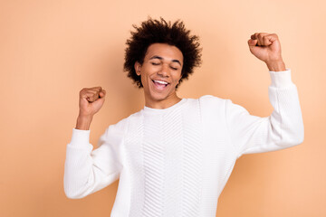 Photo of positive glad joyful man champion wear white trendy clothes celebrate victory isolated on beige color background