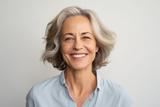 Portrait of smiling senior woman with grey hair looking at camera.