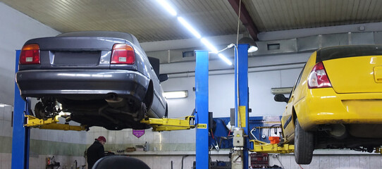 Cars on a lift in an auto repair shop