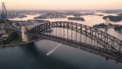 Poster Aerial drone view of Sydney Harbour Bridge, NSW Australia showing two trains crossing the bridge during an early morning sunrise in March 2024  © Steve