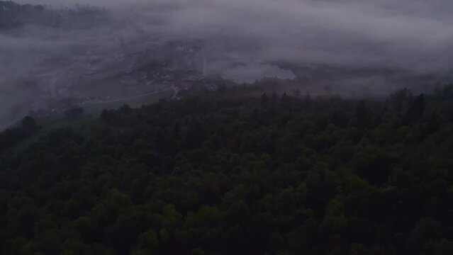 Aerial view of St. Anne's Church (Cerkev sv. Ane) on top of a mountain with low fog, Jezero, Slovenia