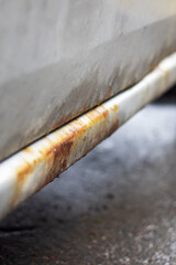 Rusty threshold of a grey old car