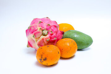 Tropical fruits such as dragon fruit, mango, and orange isolated on white background