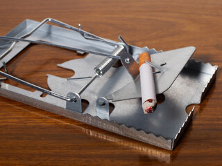 A cigarette being used as bait on a spring loaded trap. Concept of the lure of smoking tobacco,...