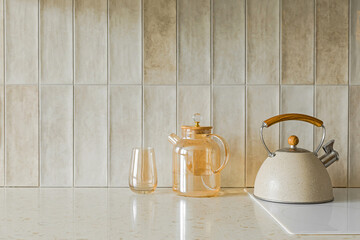 Beige stone kitchen table top, a carafe of water, a glass and a kettle on a white electric stove - 758809225
