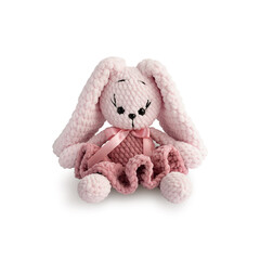 Soft pink bunny in fluffy dress, crocheted, isolated on white background. Handmade children's toy. Happy childhood concept. Close-up