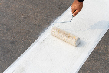 Workers are painting a pedestrian crossing.