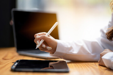 Close up of a businessperson hand using a pen on digital tablet. Creative work