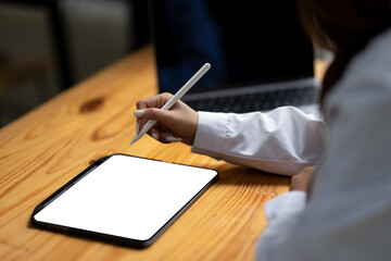 Close up of a businessperson hand using a pen on digital tablet. Creative work, white screen mockup.