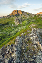 Rock formations in Sandfjorden beach by the Barents Sea near the town of Berlevåg on a beautiful summer evening, Northern Norway