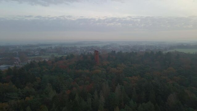 Aerial view of watchtower in middle of autumn forest