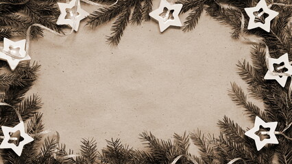Vintage Sepia Christmas Frame with Natural Accents. Pine Branches and Star Ornaments Surrounding a...