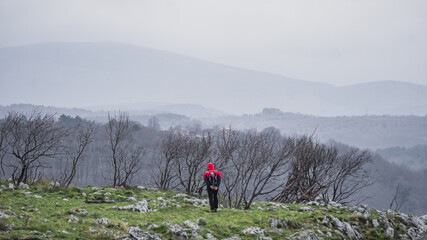 Hiker walking in the mountains on a cloudy day