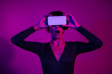 Photo portrait of pretty young girl cover eyes white screen shock wear trendy overall outfit isolated on neon light pink color background